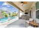 Spacious covered patio with a fan, grill, and outdoor furniture overlooking the backyard pool at 1499 Gopher Loop, Tarpon Springs, FL 34689