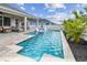 A pristine pool with built-in spa, patio seating, and lush landscaping creates a serene backyard oasis at 1499 Gopher Loop, Tarpon Springs, FL 34689