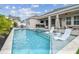 Inviting backyard pool and spa area with lounge chairs and covered patio at 1499 Gopher Loop, Tarpon Springs, FL 34689