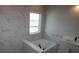 Elegant bathroom featuring marble tile, a soaking tub, and modern fixtures at 1631 Springwell Ln, Sarasota, FL 34240