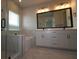 Bathroom featuring a glass-enclosed shower, soaking tub, double sink vanity and contemporary lighting at 1631 Springwell Ln, Sarasota, FL 34240