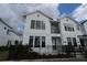 Contemporary townhome showcasing a white exterior, black framed windows, and a charming second-floor balcony at 1631 Springwell Ln, Sarasota, FL 34240