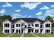 New two-story townhome featuring symmetrical design, multiple windows, and manicured lawn at 1631 Springwell Ln, Sarasota, FL 34240