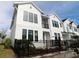 Modern two-story townhome with white siding, black windows, and a small front yard with a black fence at 1631 Springwell Ln, Sarasota, FL 34240