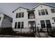 Clean shot of white townhome with black window trim and metal balcony, along with manicured front garden at 1631 Springwell Ln, Sarasota, FL 34240