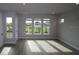 Sunlit living room with wood floors, large windows offering community views and neutral paint at 1631 Springwell Ln, Sarasota, FL 34240