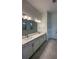Bright bathroom featuring double vanity with stone countertops and modern fixtures at 17116 Moonflower Dr, Venice, FL 34293