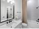 Bright bathroom with marble wall tile, black hardware, and large vanity mirror at 17116 Moonflower Dr, Venice, FL 34293