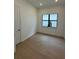 Cozy bedroom with wood floors, a window, and white walls at 17116 Moonflower Dr, Venice, FL 34293