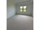 Neutral bedroom with large window offering serene outdoor views and carpet at 17116 Moonflower Dr, Venice, FL 34293