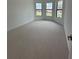 Bright bedroom featuring a neutral carpet and large windows providing ample natural light at 17116 Moonflower Dr, Venice, FL 34293