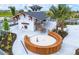 Beautiful clubhouse has outdoor fireplace, lounge seating, and fire pit area with a unique wood bench design at 17116 Moonflower Dr, Venice, FL 34293