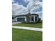 Charming single-story home with a blue garage door, landscaped yard, and sidewalk at 17116 Moonflower Dr, Venice, FL 34293