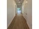 Spacious hallway with wood flooring leading to an open living area at 17116 Moonflower Dr, Venice, FL 34293