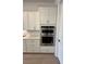 Modern kitchen with white cabinets and drawers and stainless steel double ovens at 17116 Moonflower Dr, Venice, FL 34293