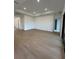 Open-concept living room with tray ceiling, hardwood floors, and natural light at 17116 Moonflower Dr, Venice, FL 34293