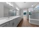 Bright bathroom featuring a double vanity, wood-look flooring and glass-enclosed shower at 1797 Pepper Grass Dr, North Port, FL 34289