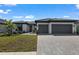 Beautiful single-story home featuring a two-car garage, manicured landscaping, and a neutral color palette at 1797 Pepper Grass Dr, North Port, FL 34289