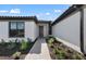Inviting front entrance with a stone walkway, beautiful landscaping, and modern architectural details at 1797 Pepper Grass Dr, North Port, FL 34289