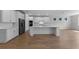 Bright, open kitchen featuring stainless steel appliances, a large island, and modern white cabinetry at 1797 Pepper Grass Dr, North Port, FL 34289