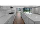 Modern kitchen with stainless steel appliances, a long quartz countertop, and seamless transition to the outdoors at 1797 Pepper Grass Dr, North Port, FL 34289