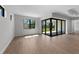 Bright room with large window and sliding glass doors to outdoor view, featuring tray ceilings and tile floors at 1797 Pepper Grass Dr, North Port, FL 34289