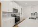 Modern kitchen features stainless steel appliances, white cabinets and countertops with tile backsplash at 2019 Wild Heron Ct, Valrico, FL 33596