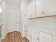 The laundry room features white cabinets, a folding counter, and wood-look floors at 2019 Wild Heron Ct, Valrico, FL 33596
