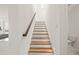 Staircase with wood treads, white risers, and a wooden handrail plus recessed lighting at 2019 Wild Heron Ct, Valrico, FL 33596