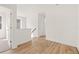 Bright upstairs hallway with wood-look floors, white walls, and a doorway leading to a carpeted room at 2019 Wild Heron Ct, Valrico, FL 33596