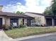 Well maintained tan home with a brown roof, trimmed windows, and a lovely, landscaped yard at 2101 Sunset Point Rd # 205, Clearwater, FL 33765