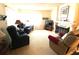 Cozy living room featuring carpeted floors, recliners, and a charming fireplace at 2101 Sunset Point Rd # 205, Clearwater, FL 33765