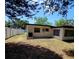 View of the backyard featuring a white fence and mature trees offering shade at 2204 Euclid S Cir, Clearwater, FL 33764