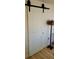 Interior sliding white barn door with black hardware, complemented by a unique lamp fixture at 2204 Euclid S Cir, Clearwater, FL 33764