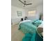 Bright bedroom featuring a ceiling fan, neutral walls, and aqua-patterned bedding with decorative pillows at 2204 Euclid S Cir, Clearwater, FL 33764