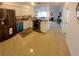 Open kitchen with stainless steel refrigerator and appliances, white cabinets, and shiny speckled flooring at 2204 Euclid S Cir, Clearwater, FL 33764