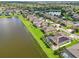 Wide aerial shot showcases a neighborhood by a lake, featuring green lawns and well-maintained homes at 2417 Cumberland Cliff Dr, Ruskin, FL 33570
