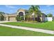 Charming home with manicured lawn, colorful landscaping, and an elegant arched entryway at 2417 Cumberland Cliff Dr, Ruskin, FL 33570