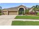 Attractive home featuring lush landscaping, a three-car garage, and a screened entry at 2417 Cumberland Cliff Dr, Ruskin, FL 33570