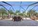 Screened-in patio with seating area, perfect for outdoor dining and relaxation with tropical view at 2417 Cumberland Cliff Dr, Ruskin, FL 33570