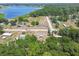 Aerial view showcases home in a lush, tree-filled landscape near a lake at 25126 Huston St, Brooksville, FL 34601
