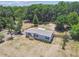 An aerial view shows the home with fenced yard surrounded by lush trees at 25126 Huston St, Brooksville, FL 34601