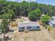 Aerial view of single story home with fenced yard, surrounded by lush trees at 25126 Huston St, Brooksville, FL 34601