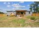 View of the backyard featuring a covered deck and newly constructed wooden fence at 25126 Huston St, Brooksville, FL 34601