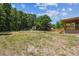Large, grassy backyard with mature trees providing shade, adjacent to covered deck at 25126 Huston St, Brooksville, FL 34601