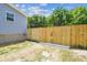 View of the backyard with a wooden fence and partial view of the home's exterior at 25126 Huston St, Brooksville, FL 34601