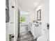 Bathroom featuring granite-topped vanity, dark wood flooring and a view to an adjacent room and window at 25126 Huston St, Brooksville, FL 34601