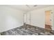 An empty bedroom with wood grain flooring, bright lighting, and a door leading to a closet or bathroom at 25126 Huston St, Brooksville, FL 34601