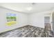 An empty bedroom with wood grain flooring, bright lighting, and a view of the outdoors through the window at 25126 Huston St, Brooksville, FL 34601