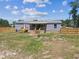 Exterior elevation of a home with new fence and covered porch for outdoor relaxation and privacy, in a well-maintained setting at 25126 Huston St, Brooksville, FL 34601